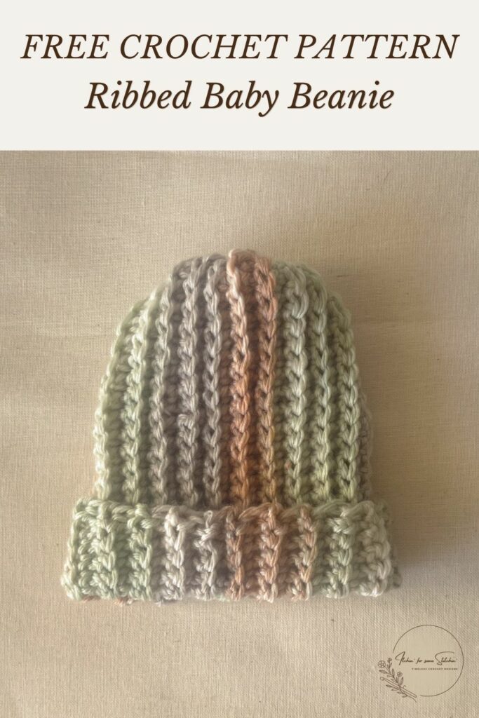 Striped ribbed crochet baby beanie in soft green, cream, gray, and brown yarn with a folded brim.