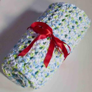Thick and Soft Crochet Seed Stitch Baby Blanket Rolled up an tied with a red ribbon