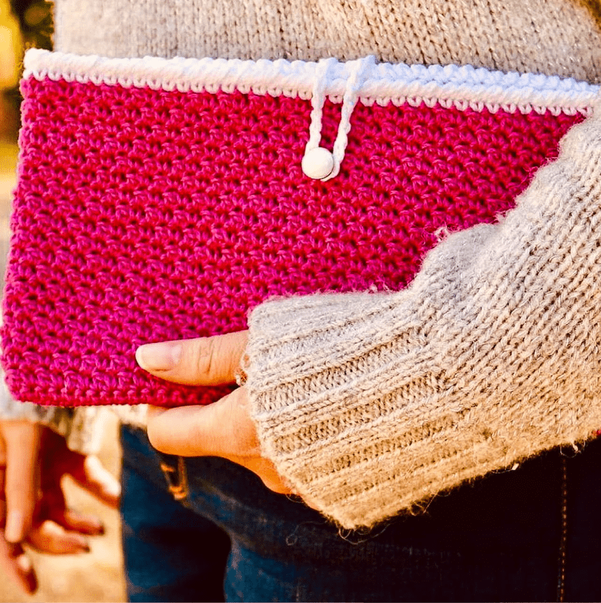 Lady holding a pink crochet seed stitch clutch purse