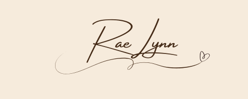 Hand written signature of RaeLynn with a heart in brown ink