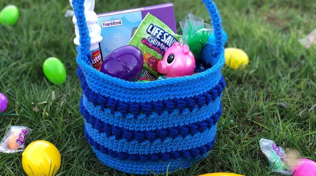 crochet Easter basket pattern that makes a filled with colorful plastic eggs sitting on grass