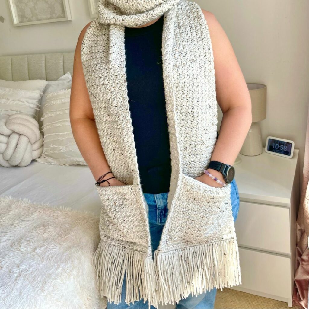 Cream crochet pocket scarf featuring textured Lemon Peel stitch, large pockets, and fringe, designed by Dreamee Crochet.