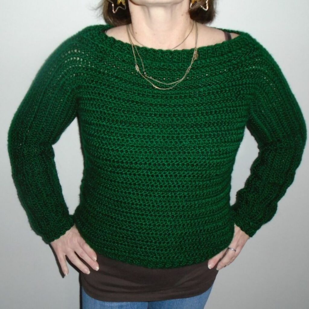 Green crochet pullover sweater with long sleeves, a wide neckline, and ribbed trim.