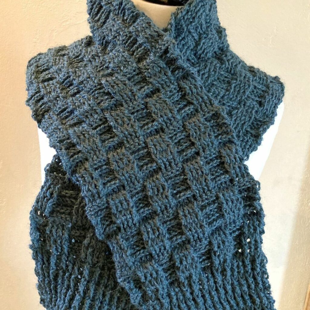 Green crochet scarf featuring a raised waffle stitch texture and ribbed ends.