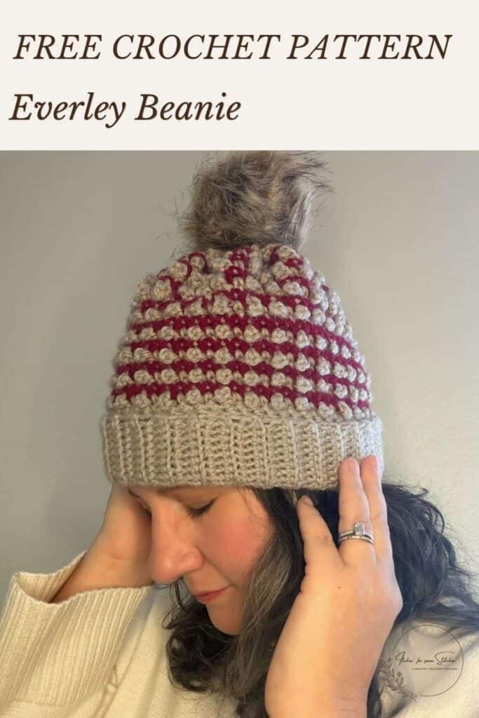 Free textured crochet beanie pattern for the Everley Beanie, featuring two-color stripes, Mini Berry stitches, and a faux fur pom-pom.